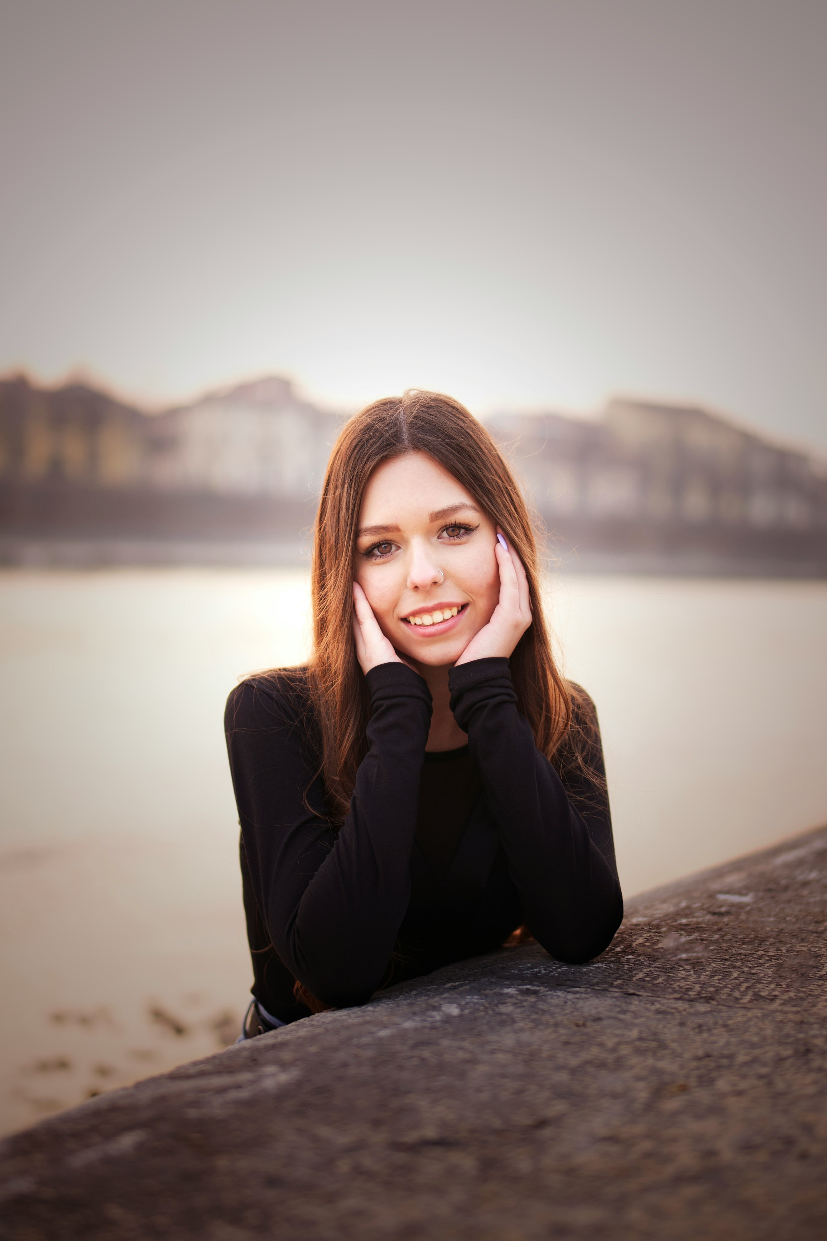 woman in black long sleeve shirt sitting on gray concrete floor during daytime